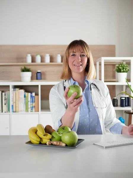 Female Nutritionist Holding Green Apple Office Studio — стоковое фото