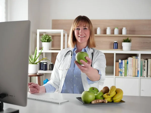 办公室工作室里拿着青苹果的女营养师 — 图库照片