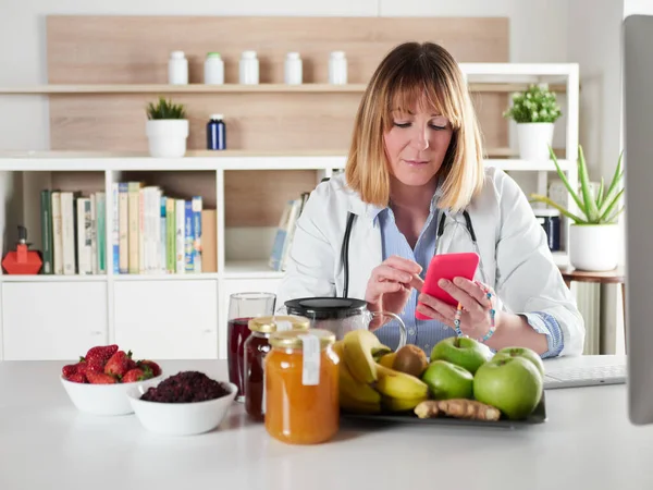 Distracted Female Nutritionist Chatting Smartphone Office Studio — ストック写真