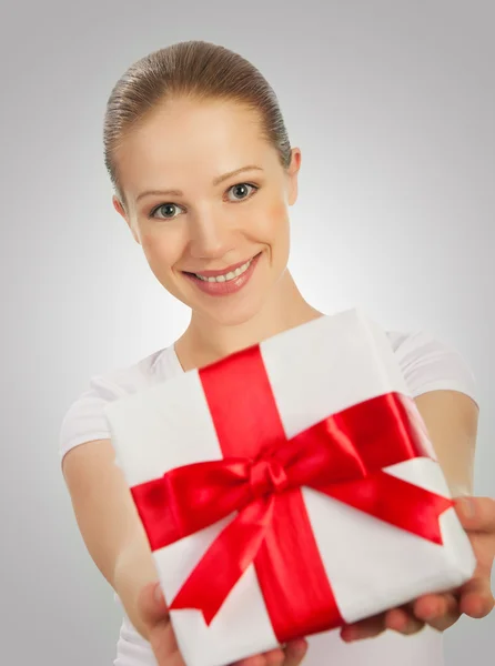 Piękna młoda kobieta z prezentem z czerwoną wstążką w t — Zdjęcie stockowe