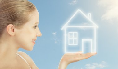 Concept housing, mortgage. woman holding in hand a house clipart