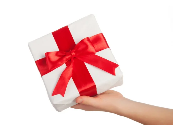 Χέρι με ένα δώρο με μια κόκκινη κορδέλα απομονωθεί σε λευκό — Φωτογραφία Αρχείου