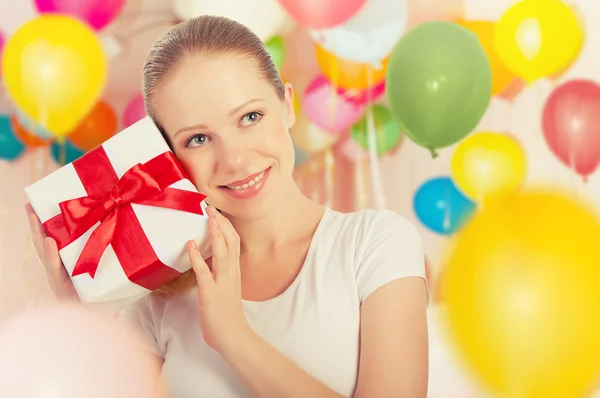 Молодая женщина с подарком с красочными воздушными шарами — стоковое фото