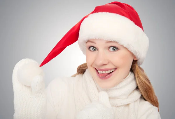 Happy funny girl in a Christmas hat on gray background — Stock Photo, Image