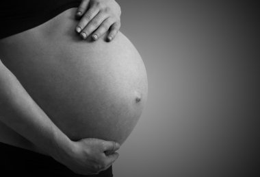 Belly of pregnant woman monochrome on dark background clipart