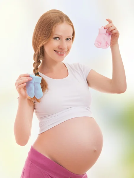 Счастливая беременная женщина и розовые носки — стоковое фото