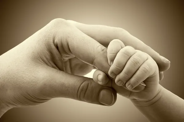 Concepto de amor y familia. Manos de madre y bebé — Foto de Stock