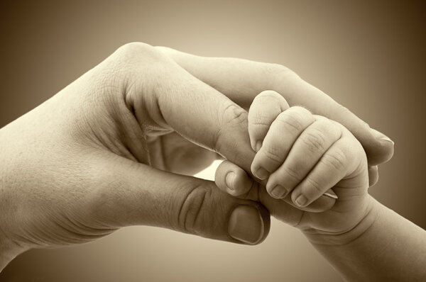 Понятие любви и семьи. Руки матери и ребенка

