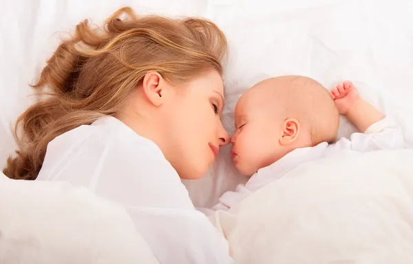 Sleeping together. mother embraces the newborn baby in bed Royalty Free Stock Photos