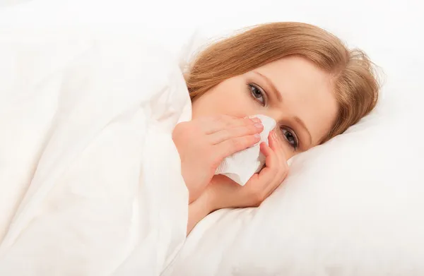 Enferma chica enferma estornuda en un pañuelo en la cama — Foto de Stock