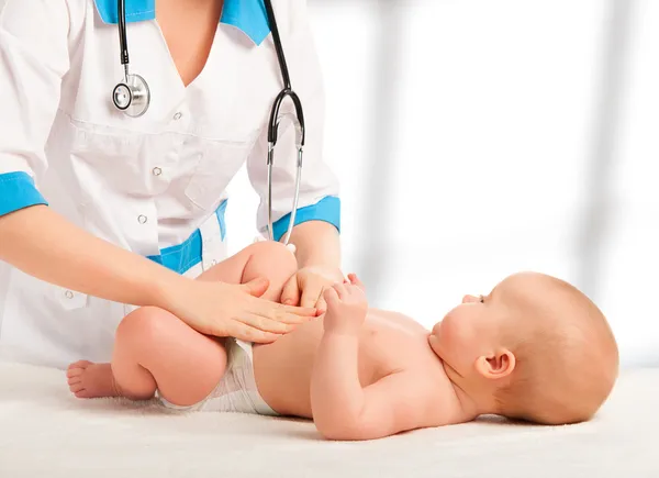 Arts onderzoekt, masseren baby buik — Stockfoto