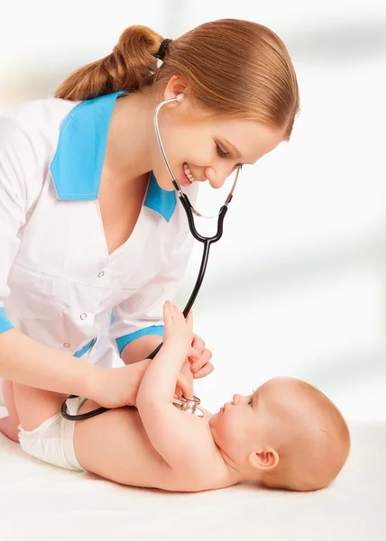 Baby and doctor pediatrician. doctor listens to the heart with s Royalty Free Stock Images