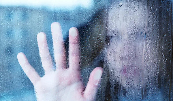 Melancolia e triste jovem mulher na janela na chuva — Fotografia de Stock