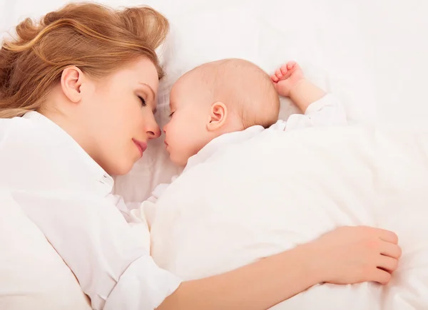 Mother embraces the newborn baby sleeping together in bed — Stock Photo, Image