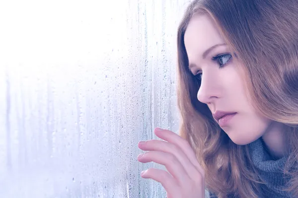 Sadness girl at the window in the rain — Stock Photo, Image