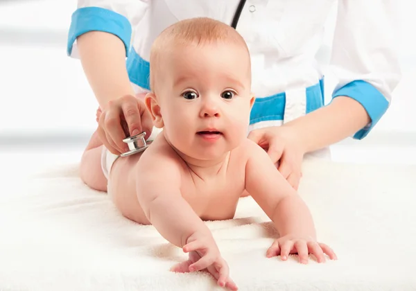 Baby and doctor pediatrician. doctor listens to the heart with s — Stock Photo, Image