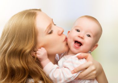 Mutlu, neşeli bir aile. Anne ve bebek öpüşüyor.
