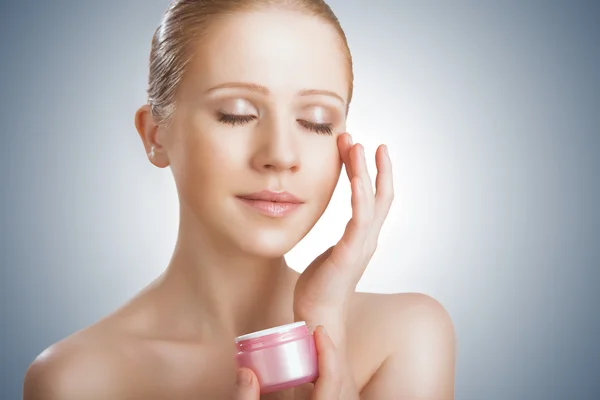 Cuidado de la piel. belleza chica con los ojos cerrados con tarro de crema — Foto de Stock