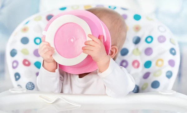 Lustiges Baby isst von rosa Teller — Stockfoto