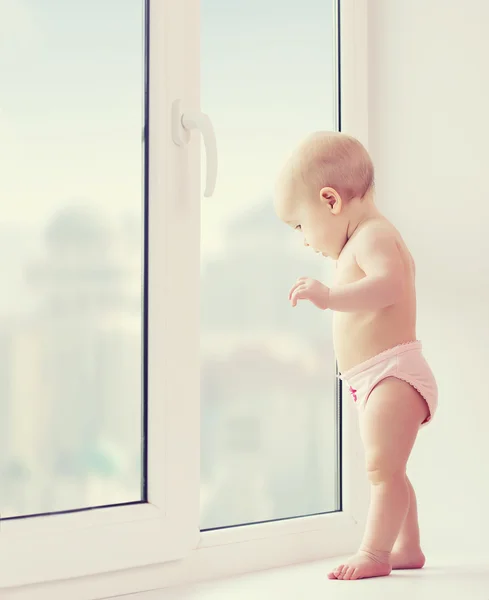 Bambina guardando fuori dalla finestra nostalgia, tristezza e attesa — Foto Stock