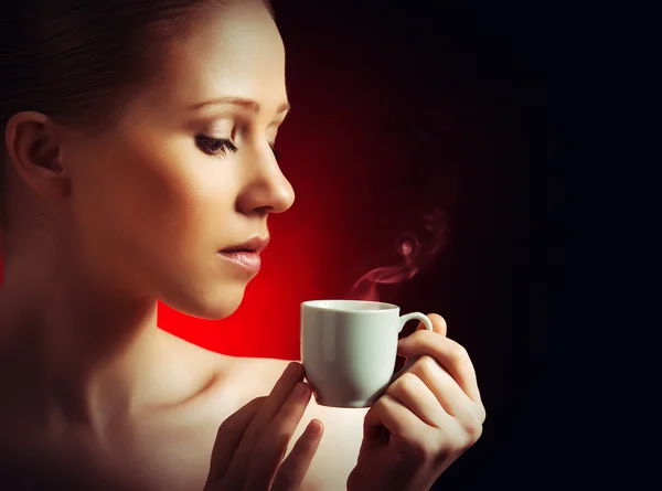 Sexy woman enjoying a hot cup of coffee on a dark background — Stock Photo, Image