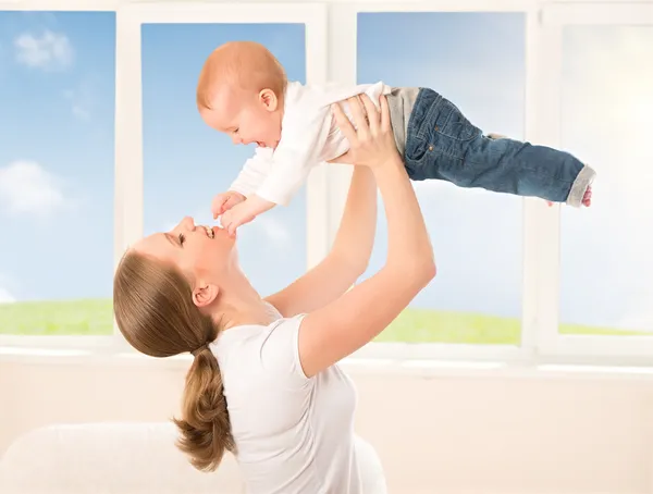 Happy family. Mother throws up baby, playing — Stock Photo, Image