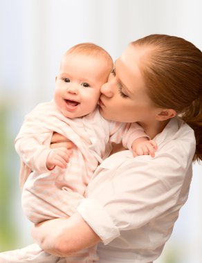 Mutlu, neşeli bir aile. Anne ve bebek öpüşüyor.
