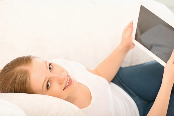 Vrouw ontspannen thuis met een tablet pc — Stockfoto