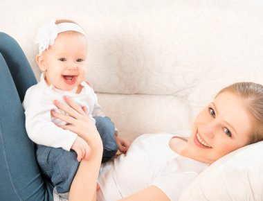 mutlu bir aile. Anne ve bebek kızı evde kanepe