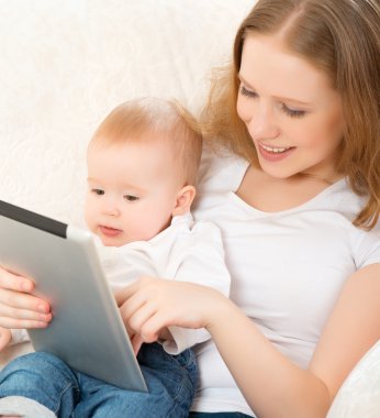 Anne ve bebek ile evde kanepede tablet bilgisayar