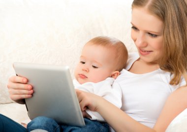 Anne ve bebek ile evde kanepede tablet bilgisayar