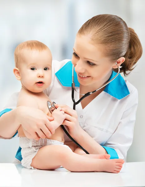 Baby and doctor pediatrician. doctor listens to the heart with s Stock Picture