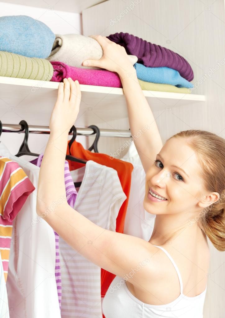 woman chooses clothes in the wardrobe closet at home