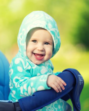 mutlu Bebek arabasındaki bebek bir yürüyüş için mavi başlıklı gülümseyen