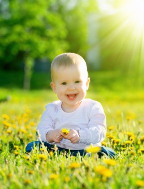 sarı çiçek dandelions inci üzerinde yeşil çayır üzerinde bebek kız