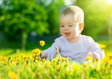 sarı çiçek dandelions inci üzerinde yeşil çayır üzerinde bebek kız