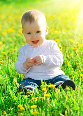sarı çiçek dandelions inci üzerinde yeşil çayır üzerinde bebek kız