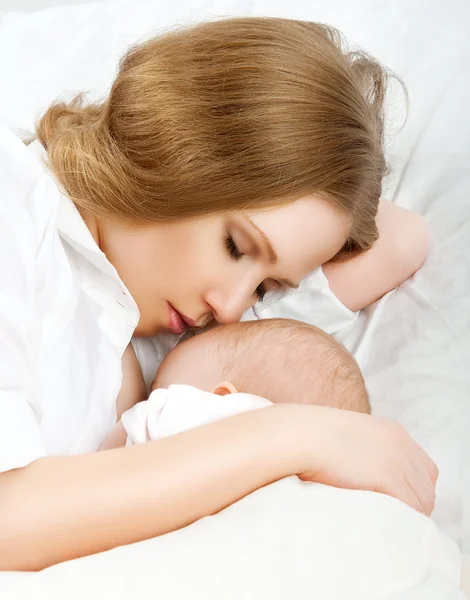 Mãe alimentando seu bebê na cama. dormindo juntos — Fotografia de Stock