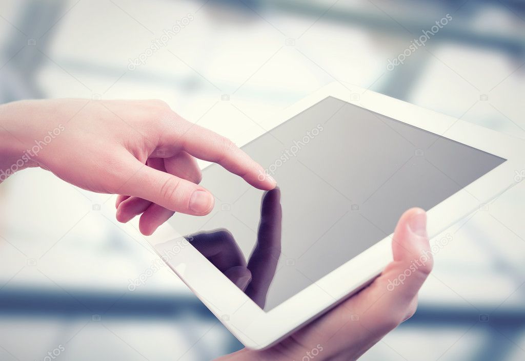 white tablet with a blank screen in the hands