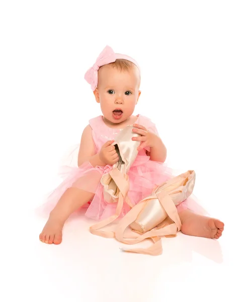 Little baby girl in a pink ballerina dress with pointe shoes — Stock Photo, Image