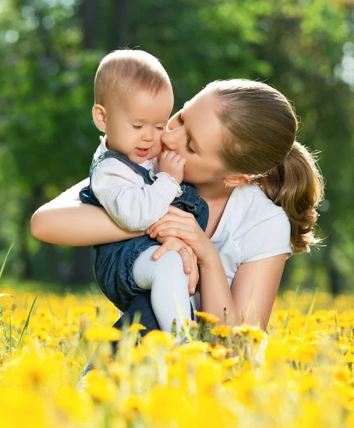 Šťastná rodina na procházce. matka líbání baby — Stock fotografie