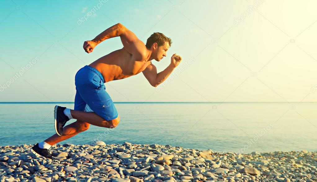 Hombre atleta corriendo por el mar al atardecer al aire libre — Foto de