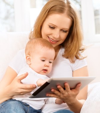 Anne ve bebek ile evde kanepede tablet bilgisayar