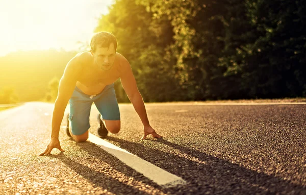 Homem atleta correndo sobre a natureza ao pôr do sol — Fotografia de Stock