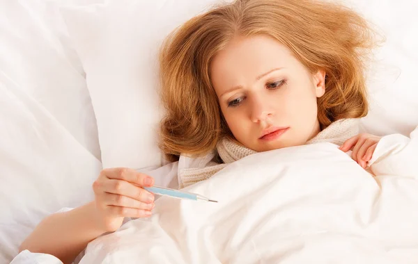 Woman with thermometer sick colds, flu, fever in bed — Stock Photo, Image