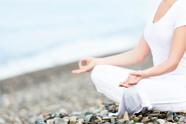 Hand av kvinna mediterar i en yogaställning på stranden — Stockfoto