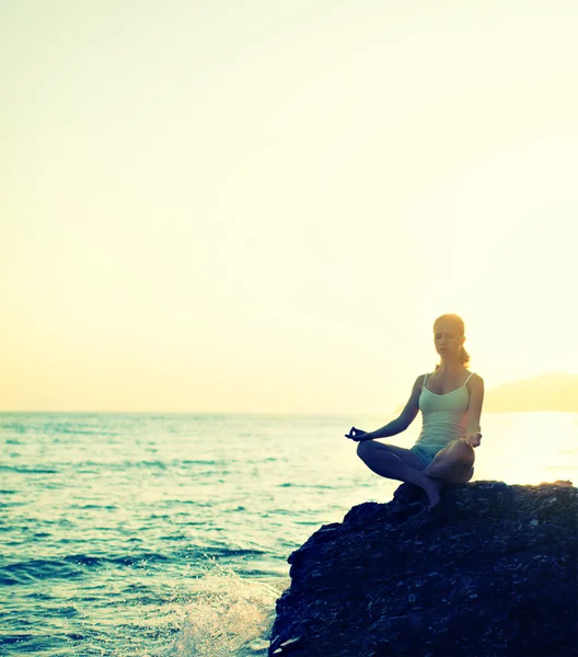 Kvinna mediterar i lotus yoga på stranden — Stockfoto