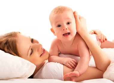 mutlu bir aile. Anne ve bebek yalan ve yatakta kucaklamak