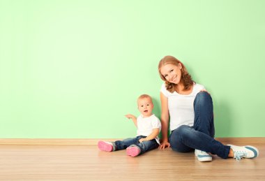 Anne ve çocuk boşalt bir yerde otururken, mutlu bir aile