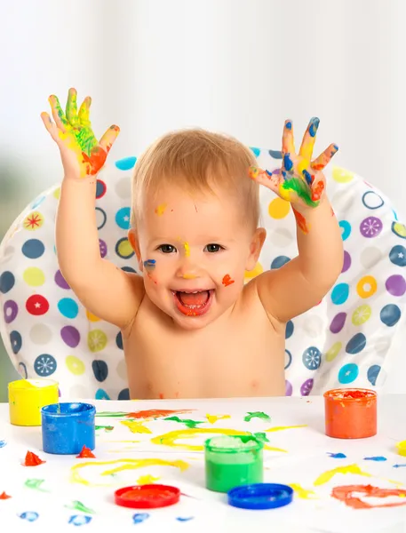 Criança feliz desenha com pinturas coloridas mãos — Fotografia de Stock